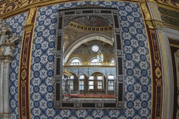 Luxurious mirror reflecting the ornate interior of a room in topkapi palace, showcasing ottoman architecture and design in istanbul, turkey