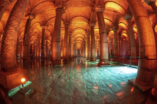 The basilica cistern, an ancient underground water reservoir in istanbul, turkey, is illuminated with orange and green lights reflecting on the turquoise water