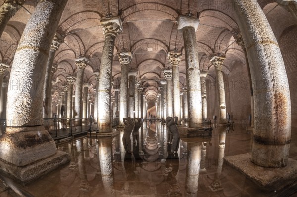 Ancient basilica cistern with many columns reflecting on water surface with sculptures and illuminated lights in istanbul, turkey