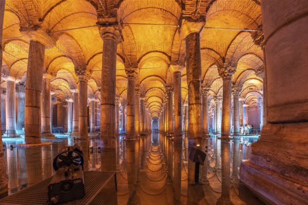 Warm orange light illuminating majestic columns and arches reflecting on the water surface of the ancient basilica cistern in istanbul, turkey
