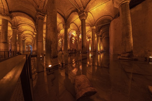 Warm lights illuminating columns and arches reflecting on the water surface of the basilica cistern in istanbul, turkey