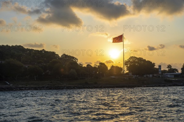 Turkish flag waving at sunset over the bosphorus strait in istanbul, turkey, creating a scenic view with warm colors and cloudy skies