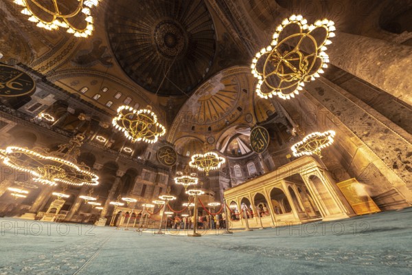 Wide angle view of the interior of the hagia sophia mosque in istanbul, turkey, showing tourists admiring the architecture