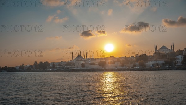 Golden sunset illuminating the historical skyline of istanbul, turkey, featuring the majestic suleymaniye mosque from across the sea