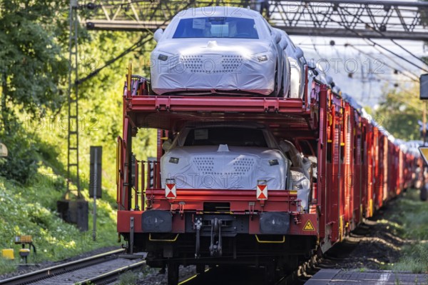 Car train with new cars on the railway line near Stuttgart. The so-called Schusterbahn is a bypass of Stuttgart main station and is mainly used by goods trains. Stuttgart, Baden-Württemberg, Germany