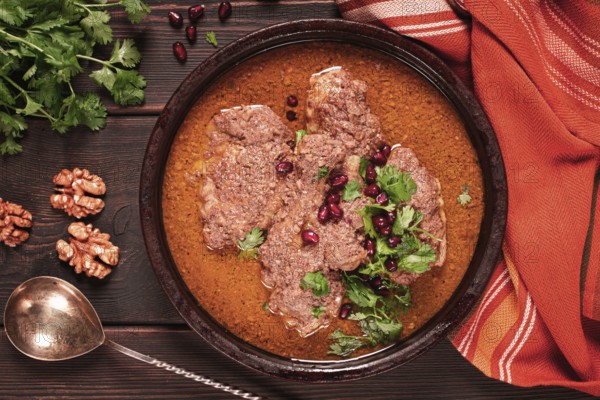 Fesenjan, an Iranian dish, stewed chicken, in walnut-pomegranate sauce, in an earthen pan, homemade, no people