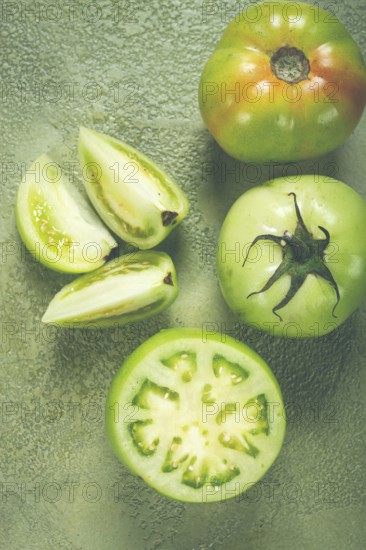 Green tomatoes, sliced on the table, unripe tomatoes, raw, selective focus, no people