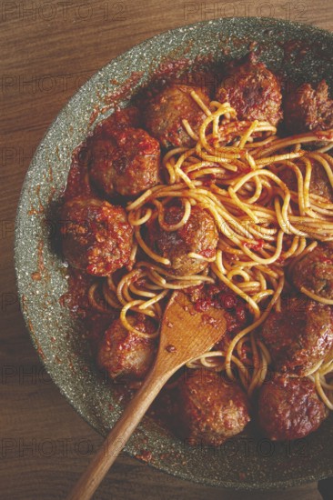 Spaghetti with meatballs, in tomato sauce, cooking in a frying pan, no people, homemade