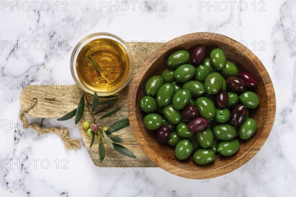 Chalkidiki olives, classic Greek green olives, in a bowl on a cutting board, top view, without people