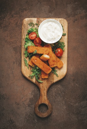 Fried fish nuggets, with white sauce, arugula and cherry, no people