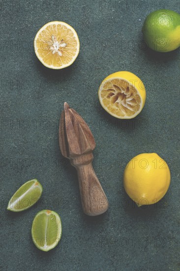 Wooden citrus reamer, manual lemon juicer, made of acacia wood, with citrus fruits on the table, top view