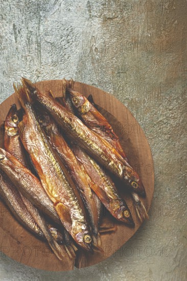 Cold smoked capelin, on a wooden bowl, top view, no people