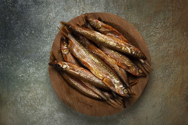 Cold smoked capelin, on a wooden bowl, top view, no people