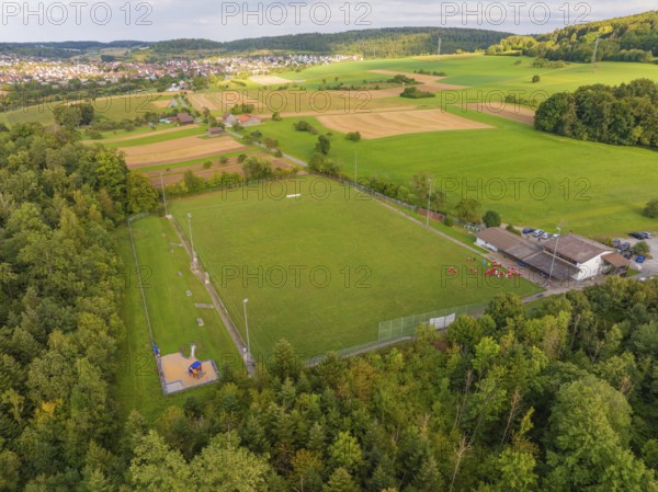 Sports field and buildings surrounded by trees and fields near a village, VFL Stammheim, Calw, Black Forest, Germany