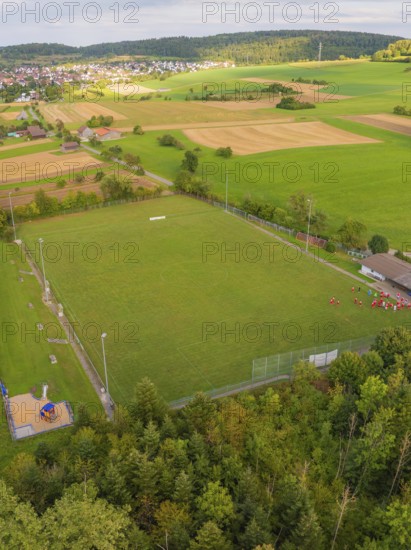 Sports field with neighbouring fields and trees near a village, VFL Stammheim, Calw, Black Forest, Germany