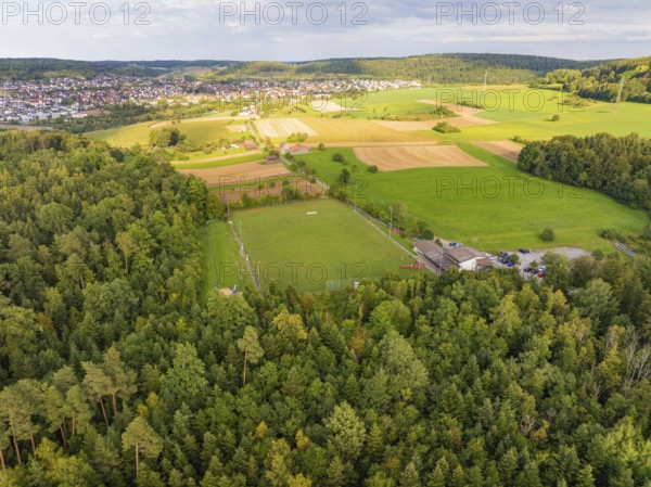 Sports ground next to woods and fields with a view of a village on the horizon, VFL Stammheim, Calw, Black Forest, Germany