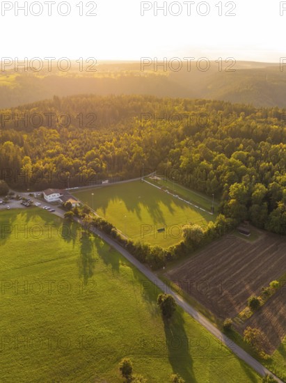 Light and shadow over green meadows and forest at sunset, VFL Stammheim, Calw, Black Forest, Germany