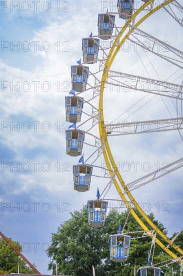 Detailed view of a giant Ferris wheel with blue cabins in front of a blue sky, Olympic Park, Munich, Germany
