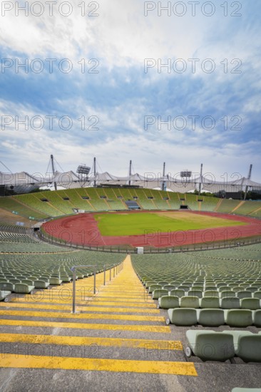Symmetrical view of a stadium from a staircase with red running track and green stands, Olympic Park, Munich, Germany