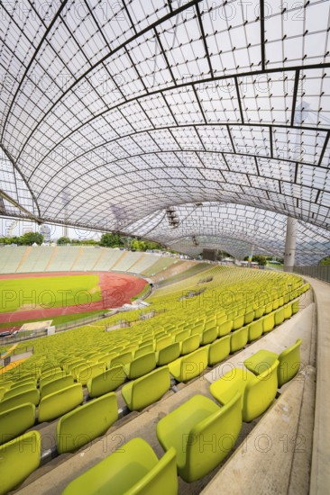 Stadium interior with yellow seats and an elegant roof design, Olympiapark, Munich, Germany