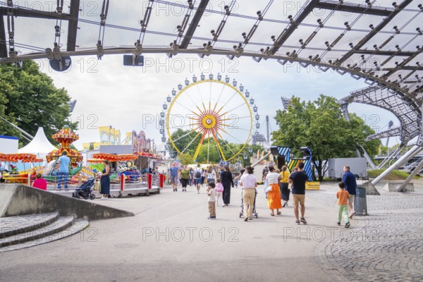 Lively amusement park with Ferris wheel and lots of people strolling around, Olympic Park, Munich, Germany