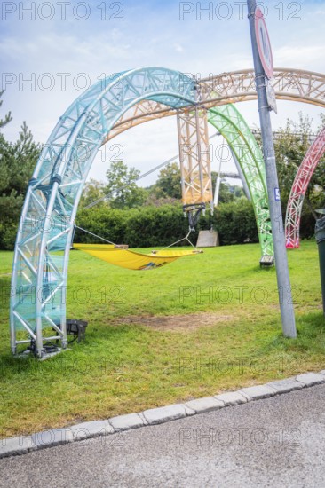 Colourful hammock on a metal scaffold in a green park, Olympic Park, Munich, Germany