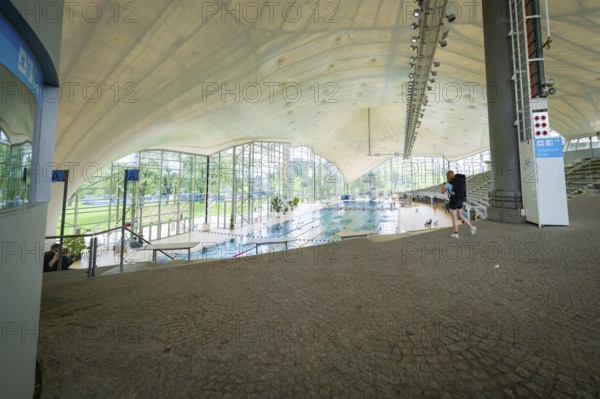 View into an indoor swimming pool with large windows that bring a lot of light onto the pool, Olympiapark, Munich, Germany