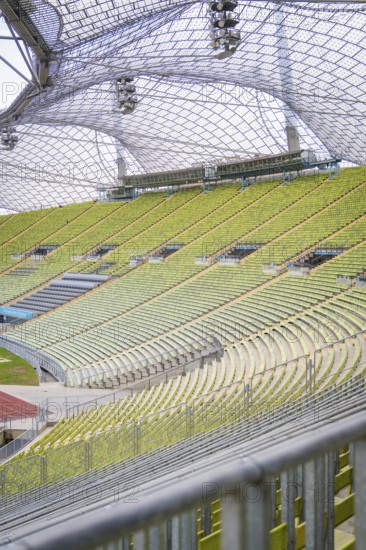 View of empty rows of seats under a striking glass roof of a sports facility, Olympiapark, Munich, Germany