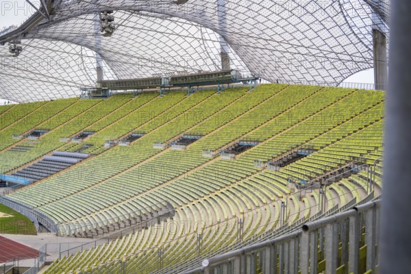 Detail view of green rows of seats in an empty modern stadium with glass roof, Olympiapark, Munich, Germany