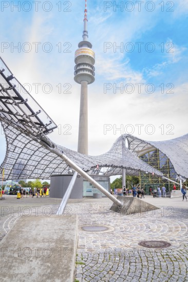 Impressive architecture below a television tower with modern design under a blue sky, Olympic Park, Munich, Germany