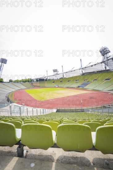 View of an empty stadium with green seats and red running track, Olympiapark, Munich, Germany