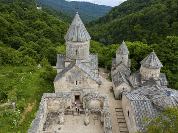 Aerial view of a classical monastery in the middle of dense forests and hilly landscape, aerial view, Haghartsin Monastery, Hagarzin, on the left Surp Astvatsatsin Church, on the right Surp Stepanos and Surp Grigor Church and a Gavit, Tavush Province, Armenia