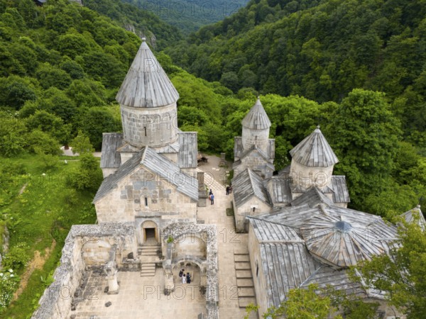 Historic stone monastery building, embedded in a wooded hilly landscape, aerial view, Haghartsin Monastery, Hagarzin, on the left Surp Astvatsatsin church, on the right Surp Stepanos and Surp Grigor churches and a gavit, Tavush province, Armenia