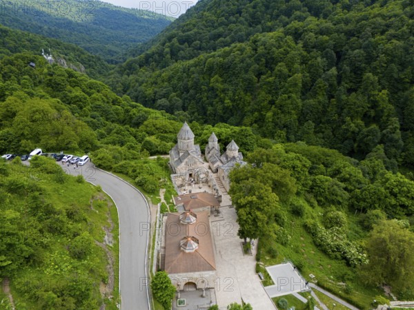 Monastery on a winding road, surrounded by dense natural vegetation and hills, aerial view, Haghartsin Monastery, Hagarzin, Tavush Province, Armenia