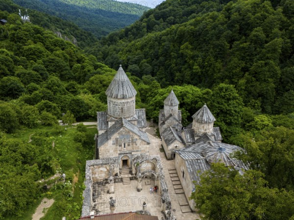 Historic monastery surrounded by dense forest and green hills, impressive stone building, aerial view, Haghartsin Monastery, Hagarzin, on the left Surp Astvatsatsin Church, on the right Surp Stepanos and Surp Grigor Church and a Gavit, Tavush Province, Armenia