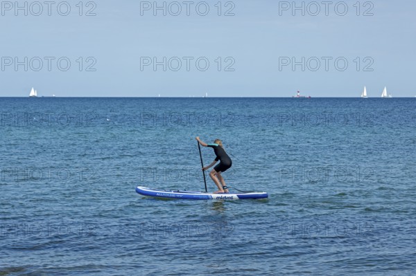 Girl stand-up paddling, Strande, Schleswig-Holstein, Germany