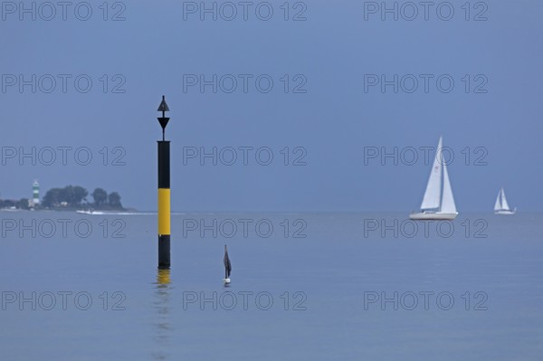 Black-yellow navigation mark, in the background lighthouse Bülk, sailing boats, Falckenstein, Kiel, Schleswig-Holstein, Germany