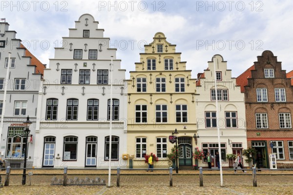 Historic stepped gabled houses on the market square, Dutch merchants' houses in the old town, passers-by, Friedrichstadt, Germany