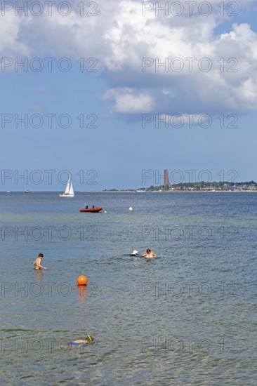 Sailing boat, rubber dinghy, people bathing, in the background the naval memorial in Laboe, Kiel Fjord, Falckenstein, Kiel, Schleswig-Holstein, Germany