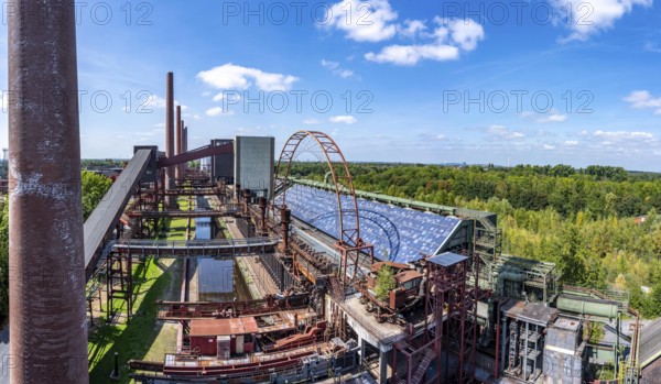 The Zollverein coking plant, on the right the works swimming pool, always in operation during the North Rhine-Westphalia summer holidays, former art object, now bathing fun against the backdrop of what was once the largest central coking plant in Europe, closed in 1993, part of the UNESC World Heritage Zollverein Coal Mine Industrial Complex, Essen, North Rhine-Westphalia, Germany