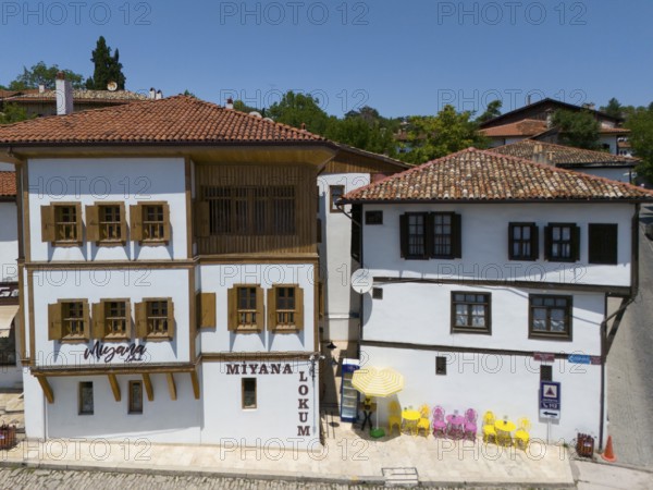 Two historic buildings with wooden windows and red roofs in sunny weather in a quiet street scene, aerial view, traditional Ottoman konaks, Safranbolu, UNESCO World Heritage Site, Karabük Province, Black Sea Region, Central Anatolia, Turkey
