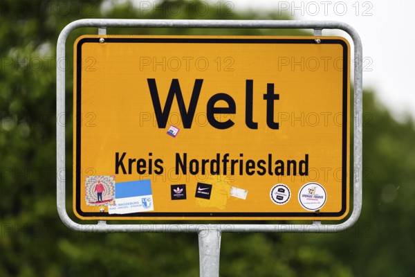 Place name sign world, inscription, many stickers, Eiderstedt peninsula, North Frisia, Germany
