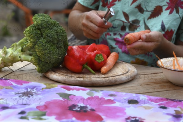 Various vegetables being prepared for a meal, carrots being peeled, Bavaria, Germany