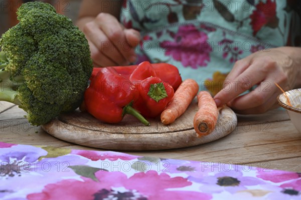 Fresh vegetables on a wooden board, broccoli, carrots and peppers, Bavaria, Germany