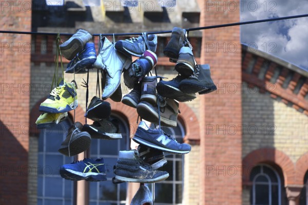 Shoes hanging on a leash in the courtyard of a residential home for addicts, each shoe a reminder of a deceased person, Baden-Württemberg
