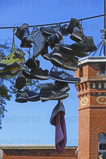 Shoes hanging on a leash in the courtyard of a residential home for addicts, each shoe a reminder of a deceased person, Baden-Württemberg