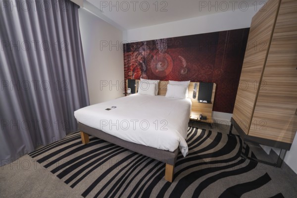 Cosy hotel room with modern design, elegant curtains and creative carpet pattern, Munich, Germany