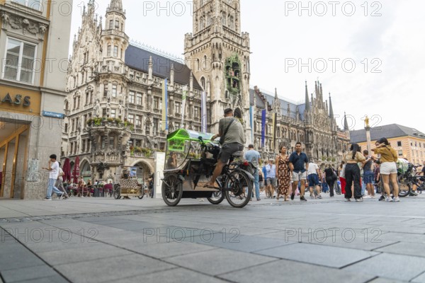 Lively town hall square with tourists in front of impressive Gothic architecture, Marienplatz, Munich, Germany