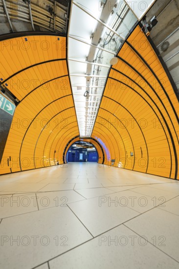 Orange tunnel with symmetrical structures and tiles leading into the depths, Marienplatz, Munich, Germany