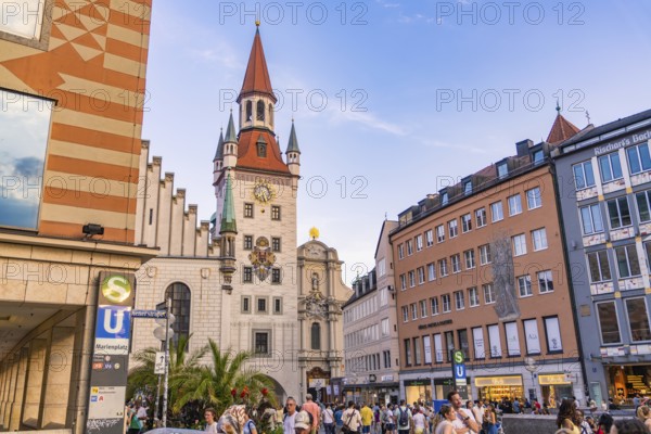 Busy street in front of historic tower with people in the city centre on a clear day, Munich, Germany